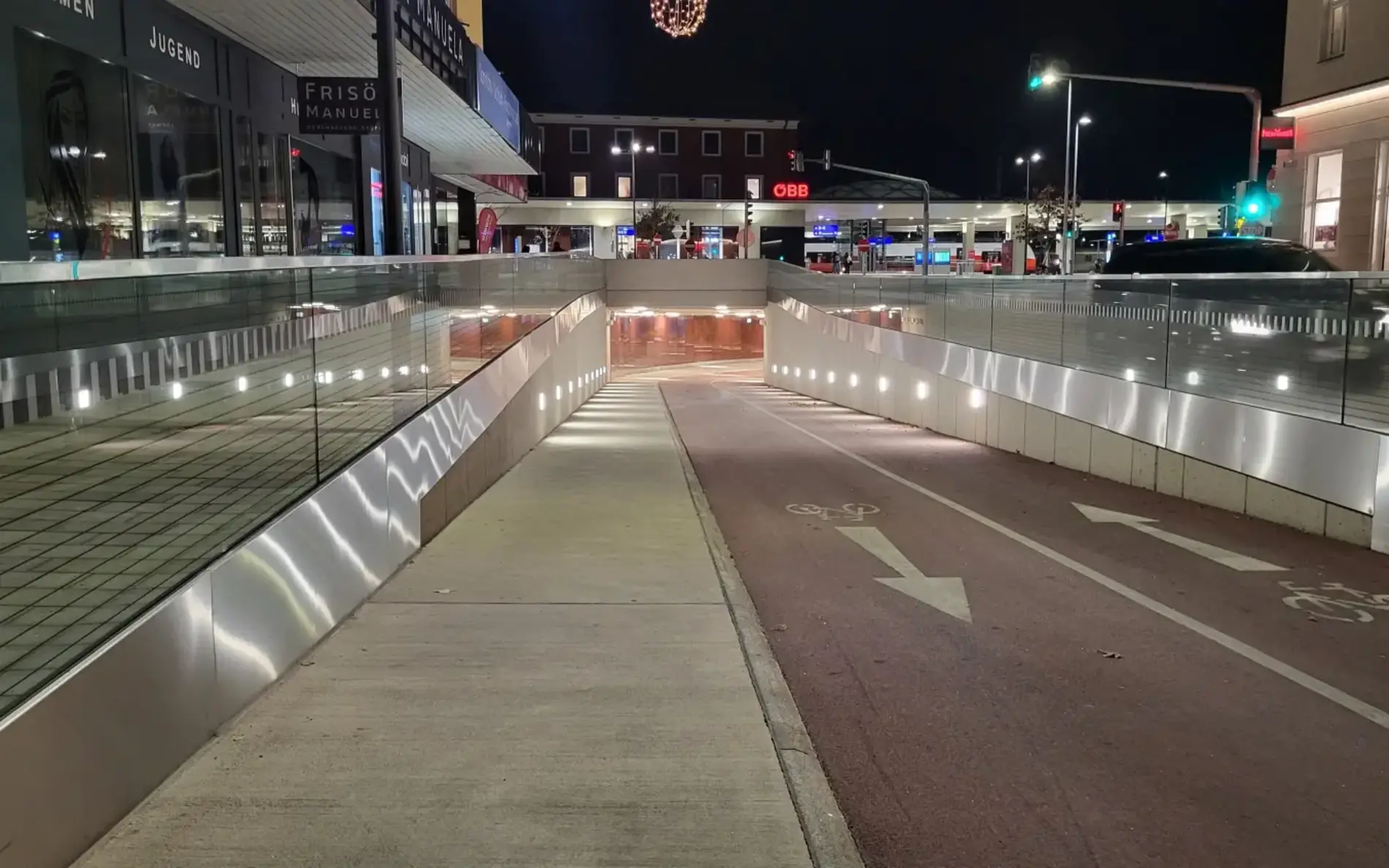 Ein breiter roter Radweg und ein Gehweg, der direkt in den Bahnhof hinein führt.