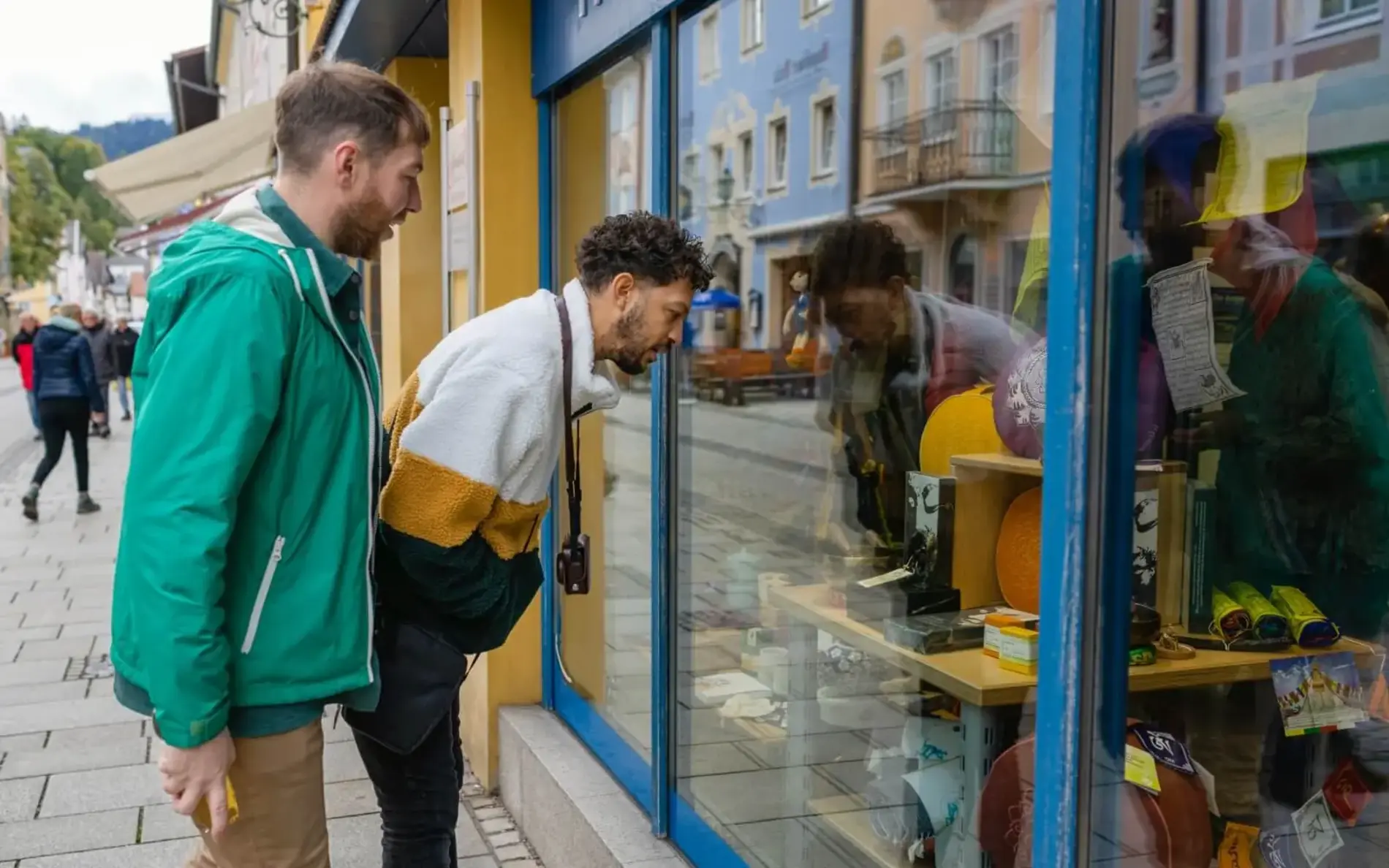 zwei junge Männer stehen vor einem Geschäft und schauen in die Auslage