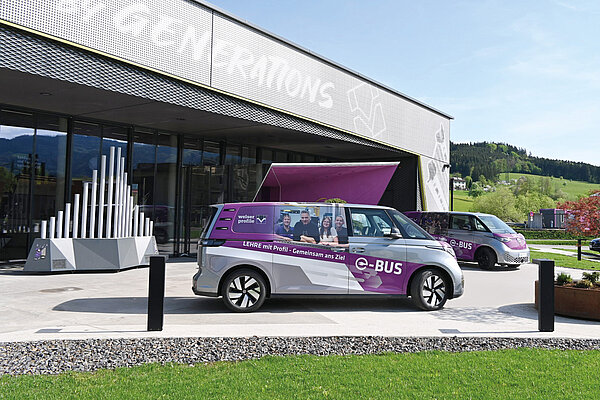 Die elektrischen Kleinbusse von Welser Profile stehen vor dem Betriebsgebäude.