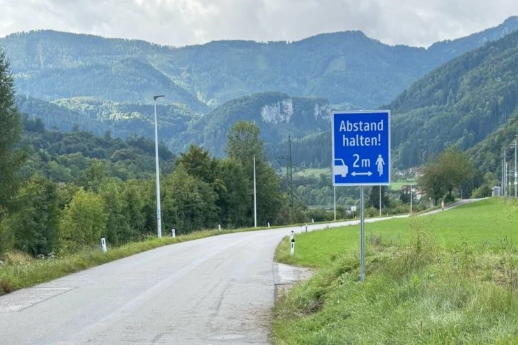 Hinweisschild auf einer Landesstraße mit "Abstand halten 2m". 