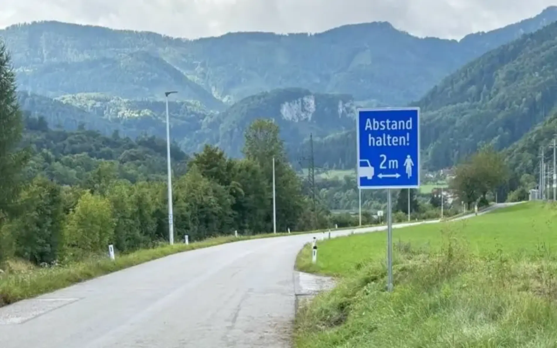 Hinweisschild auf einer Landesstraße mit "Abstand halten 2m". 