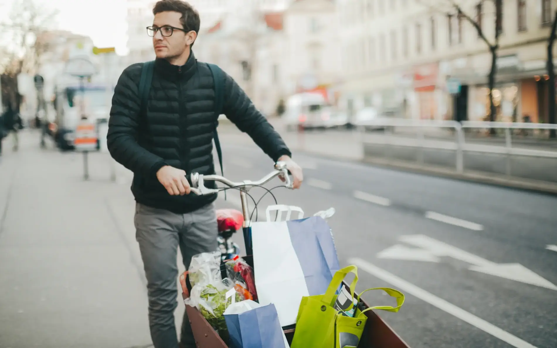 Mann fährt mit Transportrad voller Gepäck und Sackerl
