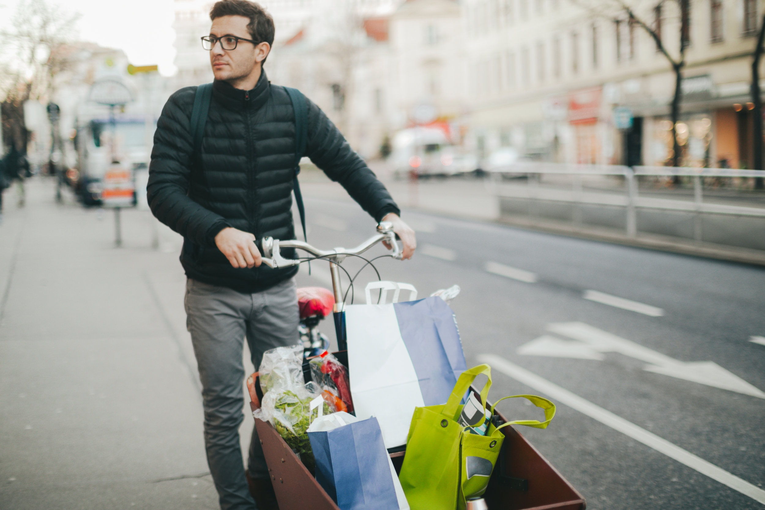 Mann fährt mit Transportrad voller Gepäck und Sackerl