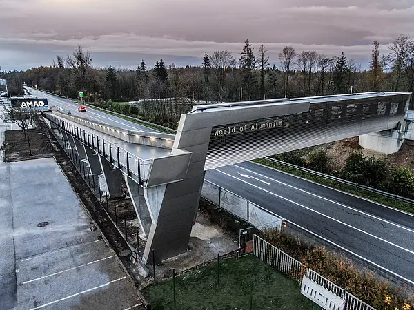 Fuß- und Radbrücke über Straße führt zu einem Gebäude