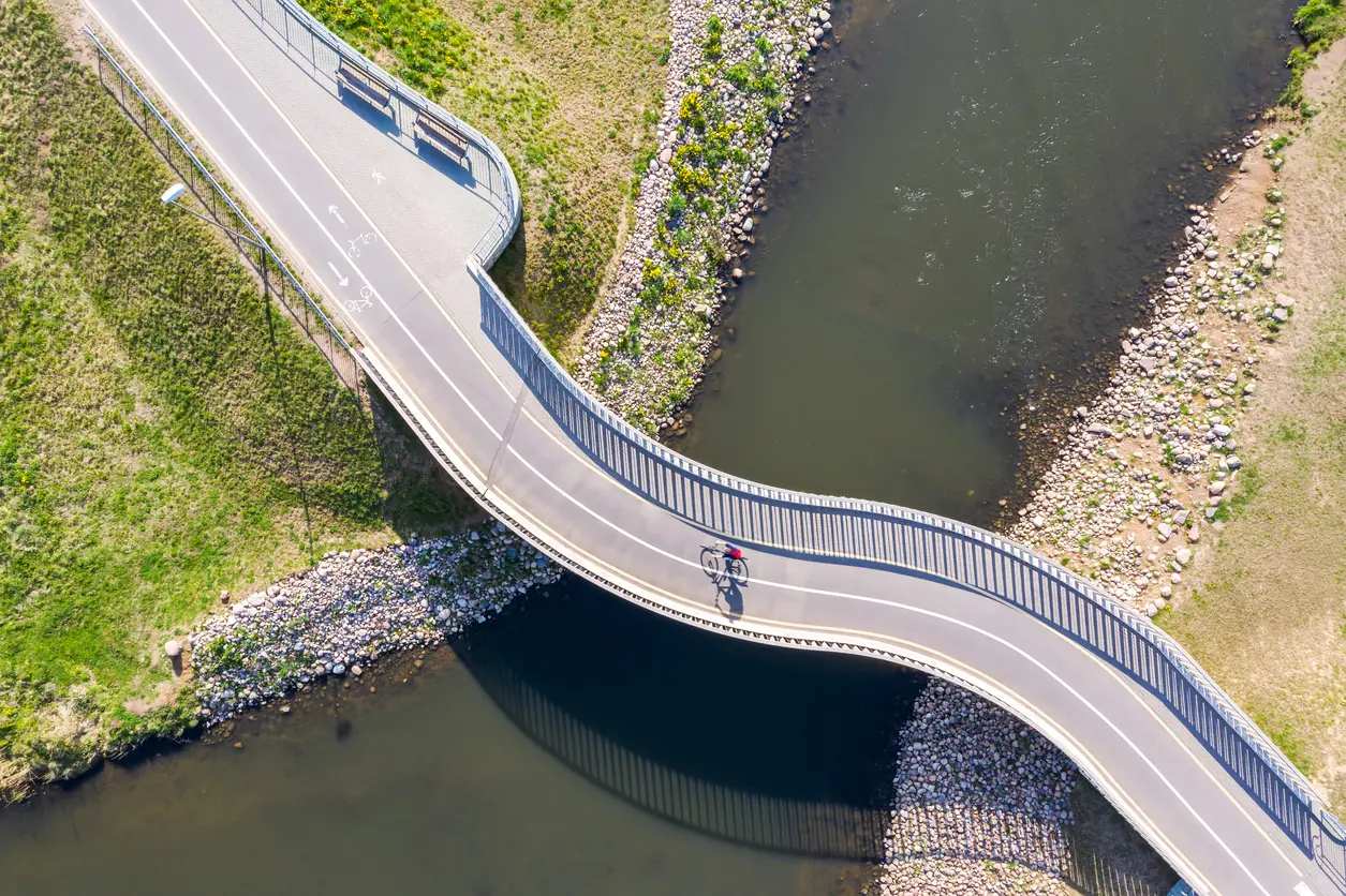 Vogelperspektive einer Radbrücke über einen Fluss
