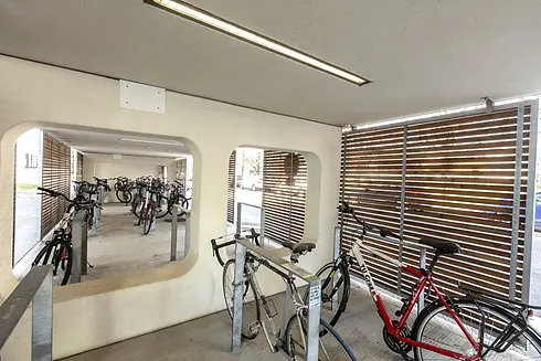 Moderne Fahrradabstellplätze mit Überdachung, Anlehnbügel, Deckenbeleuchtung und hözerner Seitenverkleidung
