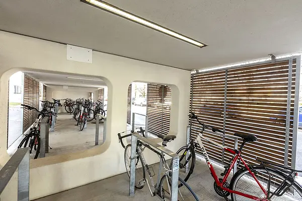 Moderne Fahrradabstellplätze mit Überdachung, Anlehnbügel, Deckenbeleuchtung und hözerner Seitenverkleidung