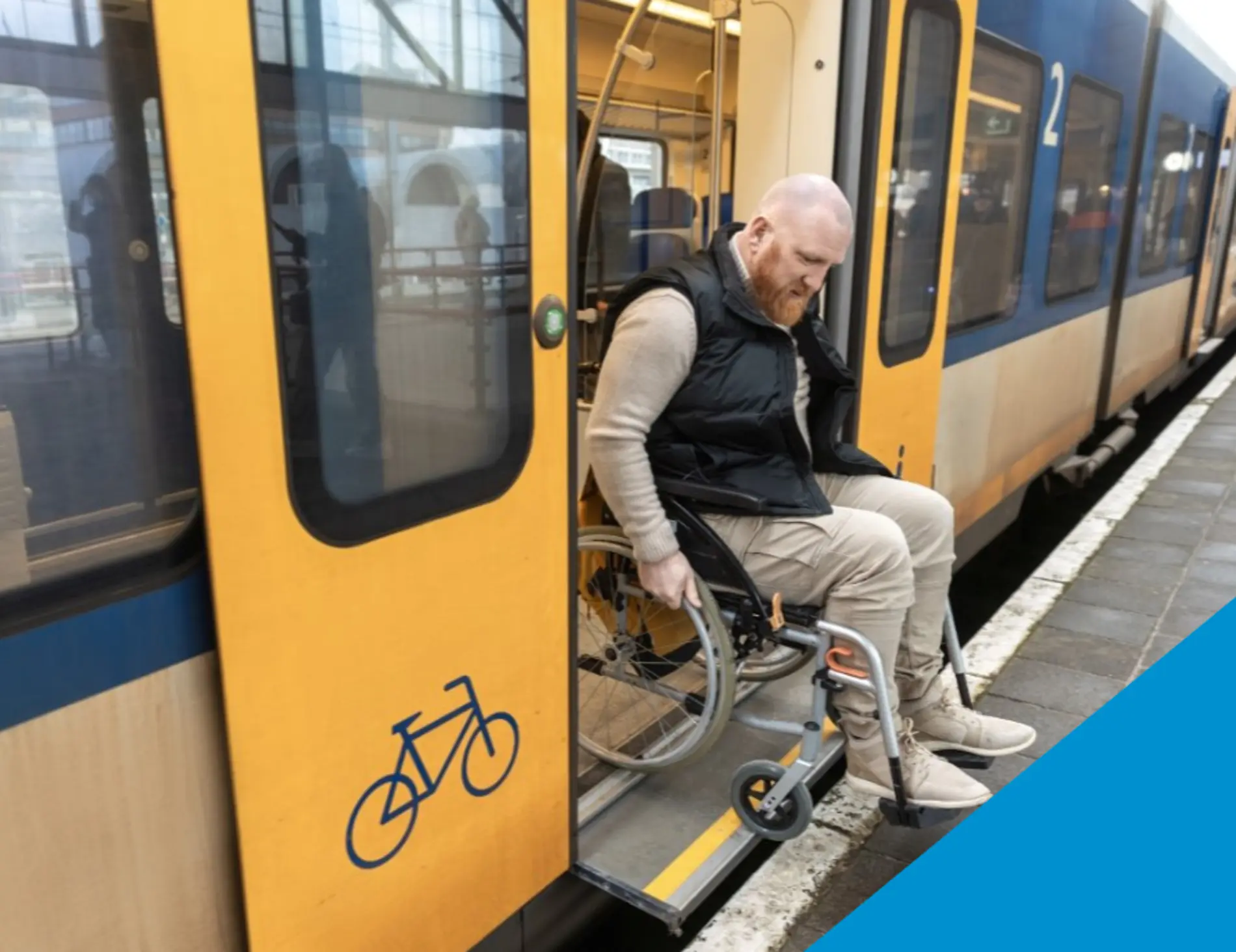 A man rolls off the train onto the platform in his wheelchair