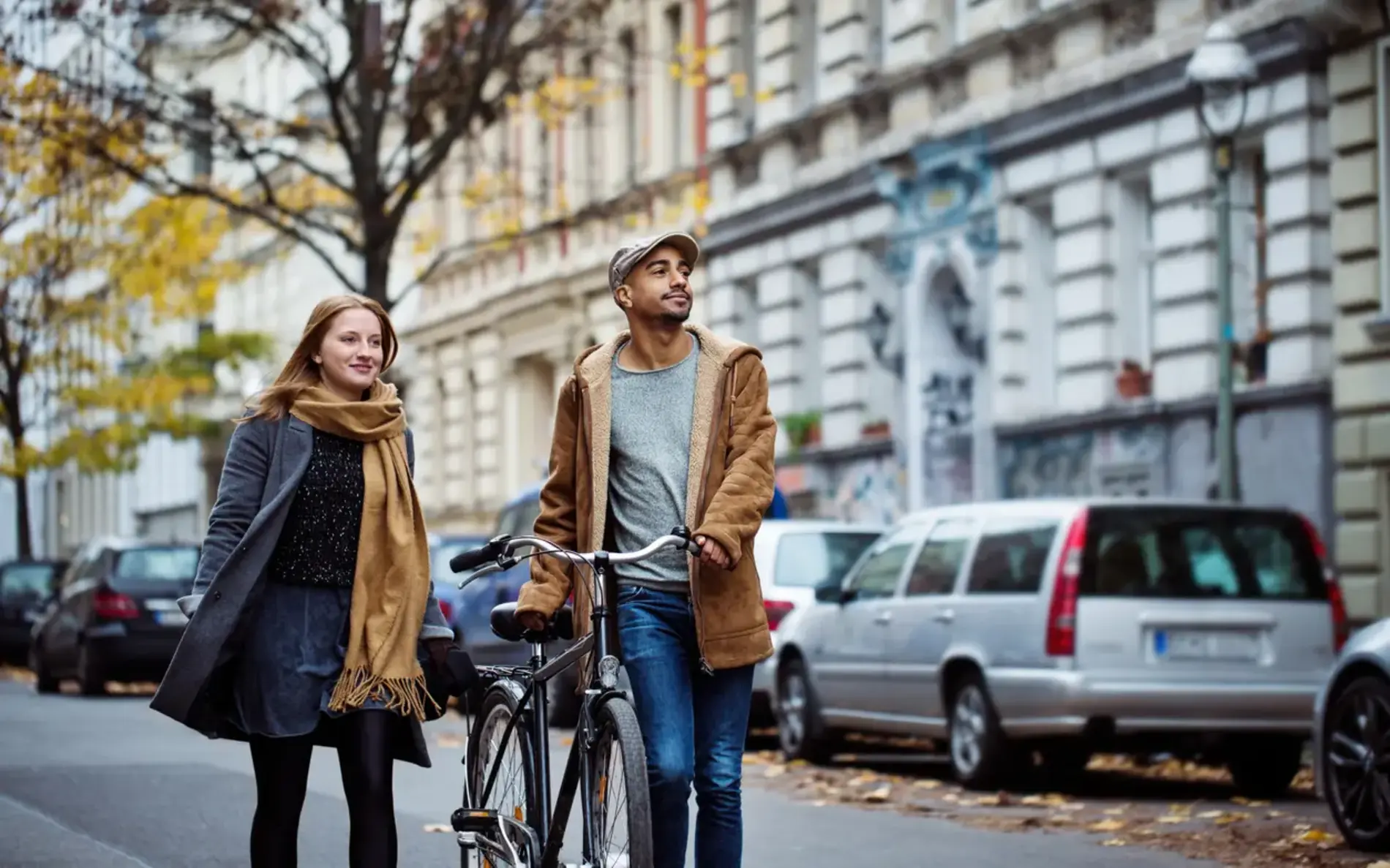 Mann schiebt Rad, eine Frau begleitet ihn zu Fuß