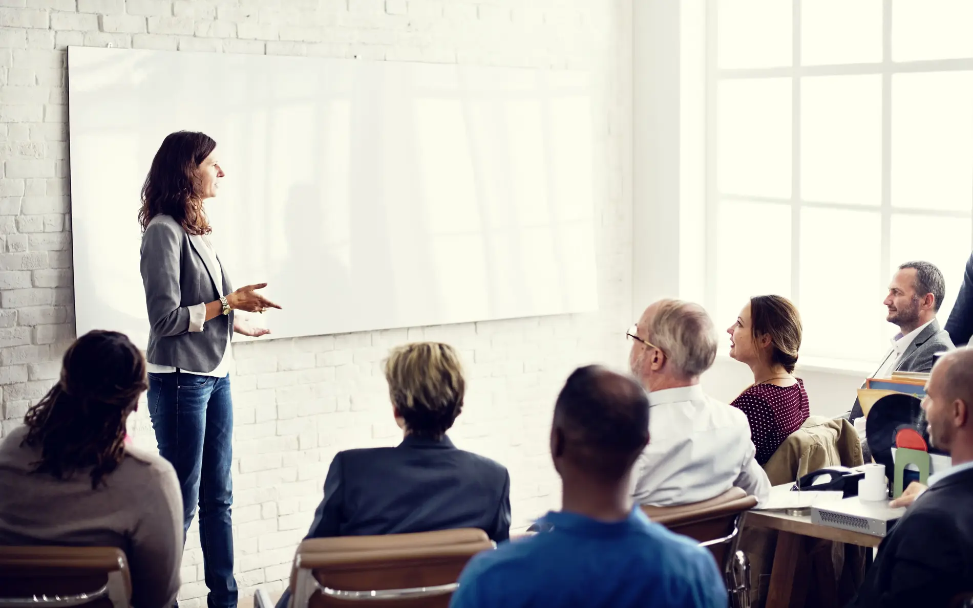 Frau steht vor Gruppe und präsentiert