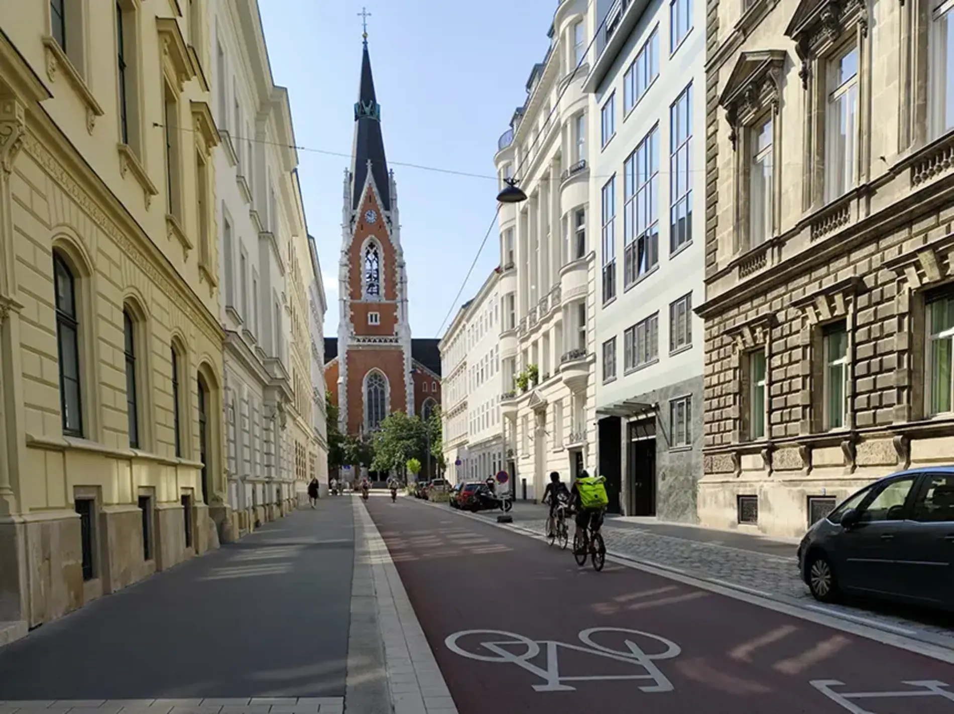 Blick auf die neue rote asphaltierte Fahrradstraße in der Argentinierstraße, im Hintergrund die St. Elisabeth Kirche